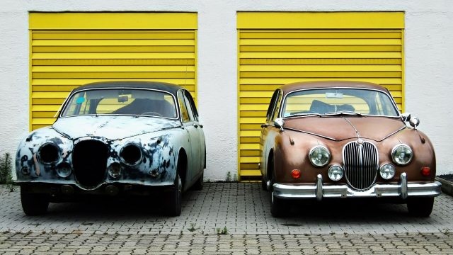 Retro cars in front of yellow garage